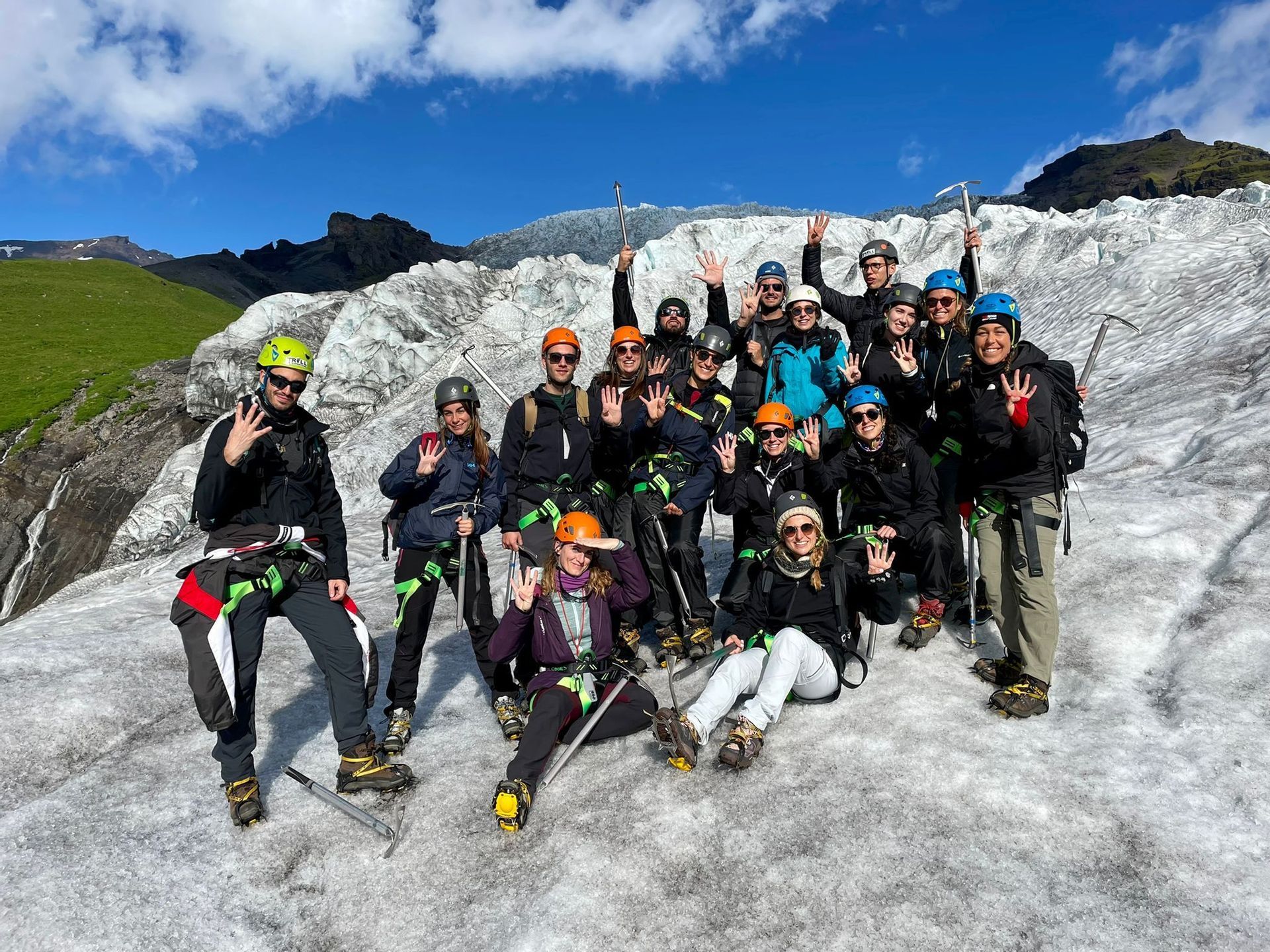 Un gruppo WeRoad in posa su un ghiacciaio, con caschi, imbracature e piccozze.