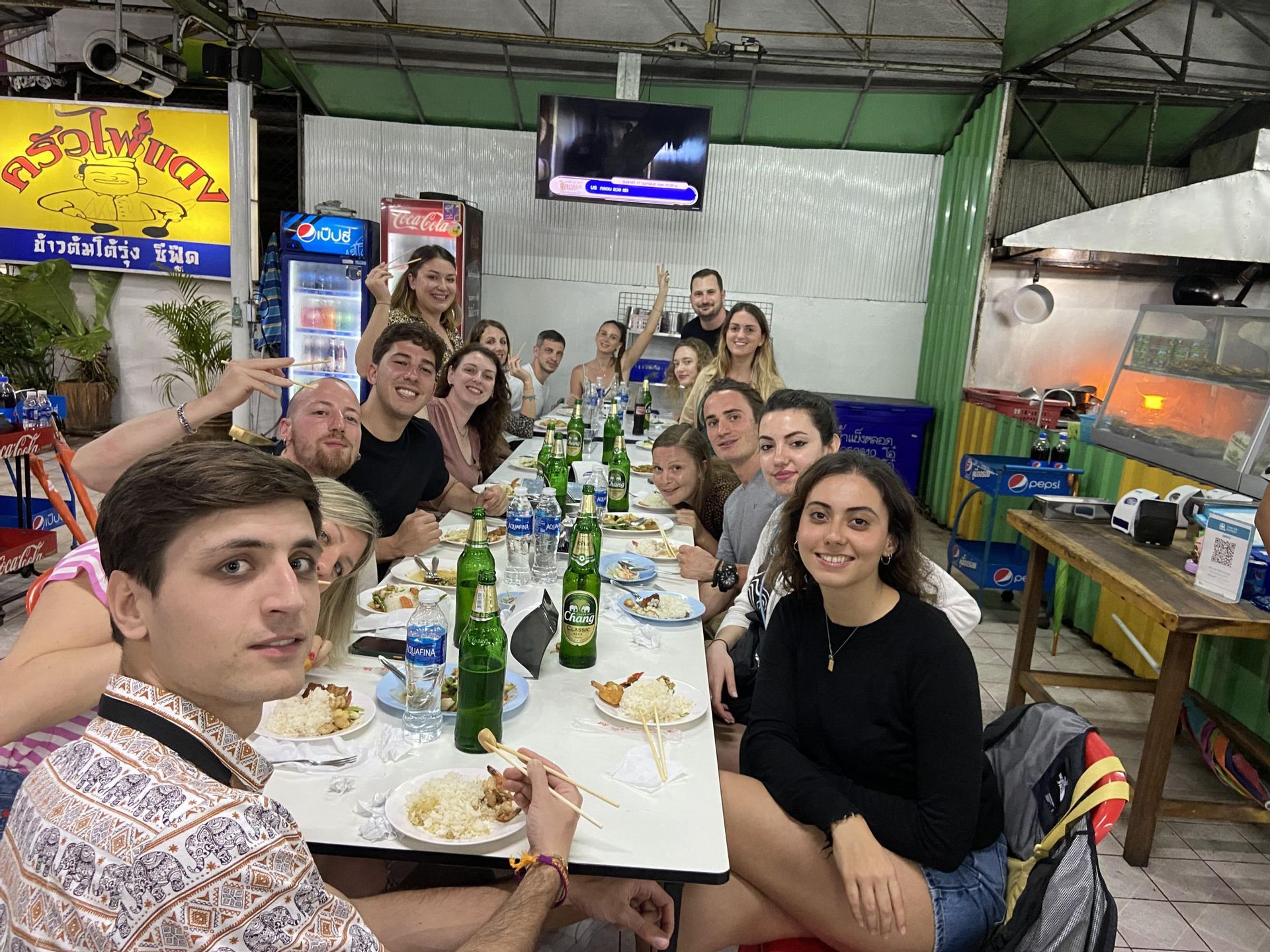 Un gruppo WeRoad a cena in un ristorante locale, seduto a un lungo tavolo e sorridendo alla macchina fotografica.