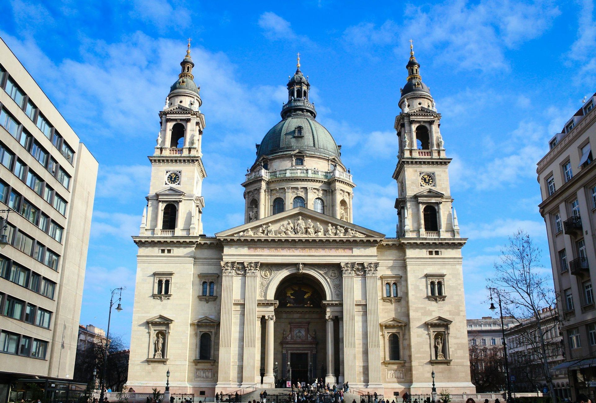 Die beeindruckende Fassade einer neoklassizistischen Basilika mit zentraler Kuppel und zwei Glockentürmen unter blauem Himmel.