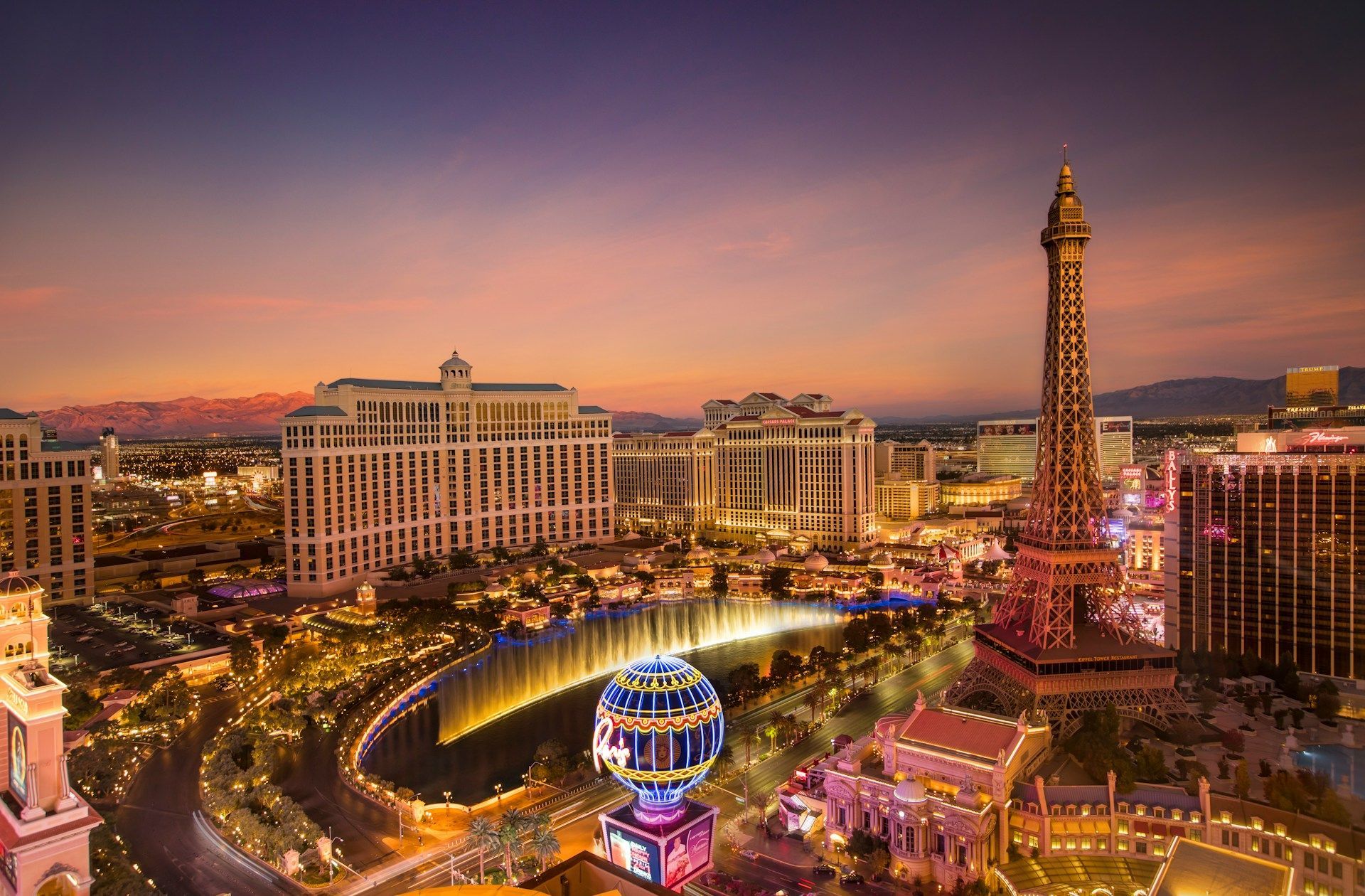 Una vista aerea della Las Vegas Strip al tramonto, con la replica illuminata della Torre Eiffel e le fontane del Bellagio.