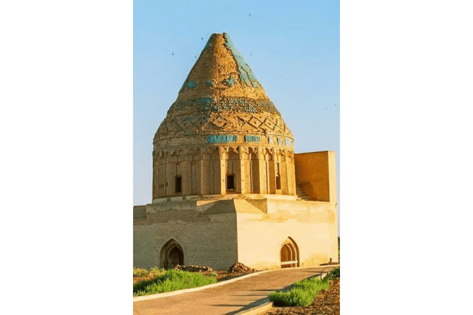Mausoleo storico in pietra color sabbia con cupola conica, dettagli in piastrelle blu e intricato lavoro in mattoni.