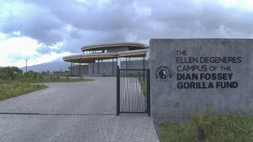 Le panneau d'entrée du Campus Ellen DeGeneres du Fonds Dian Fossey pour les Gorilles, avec le bâtiment moderne visible derrière un portail.