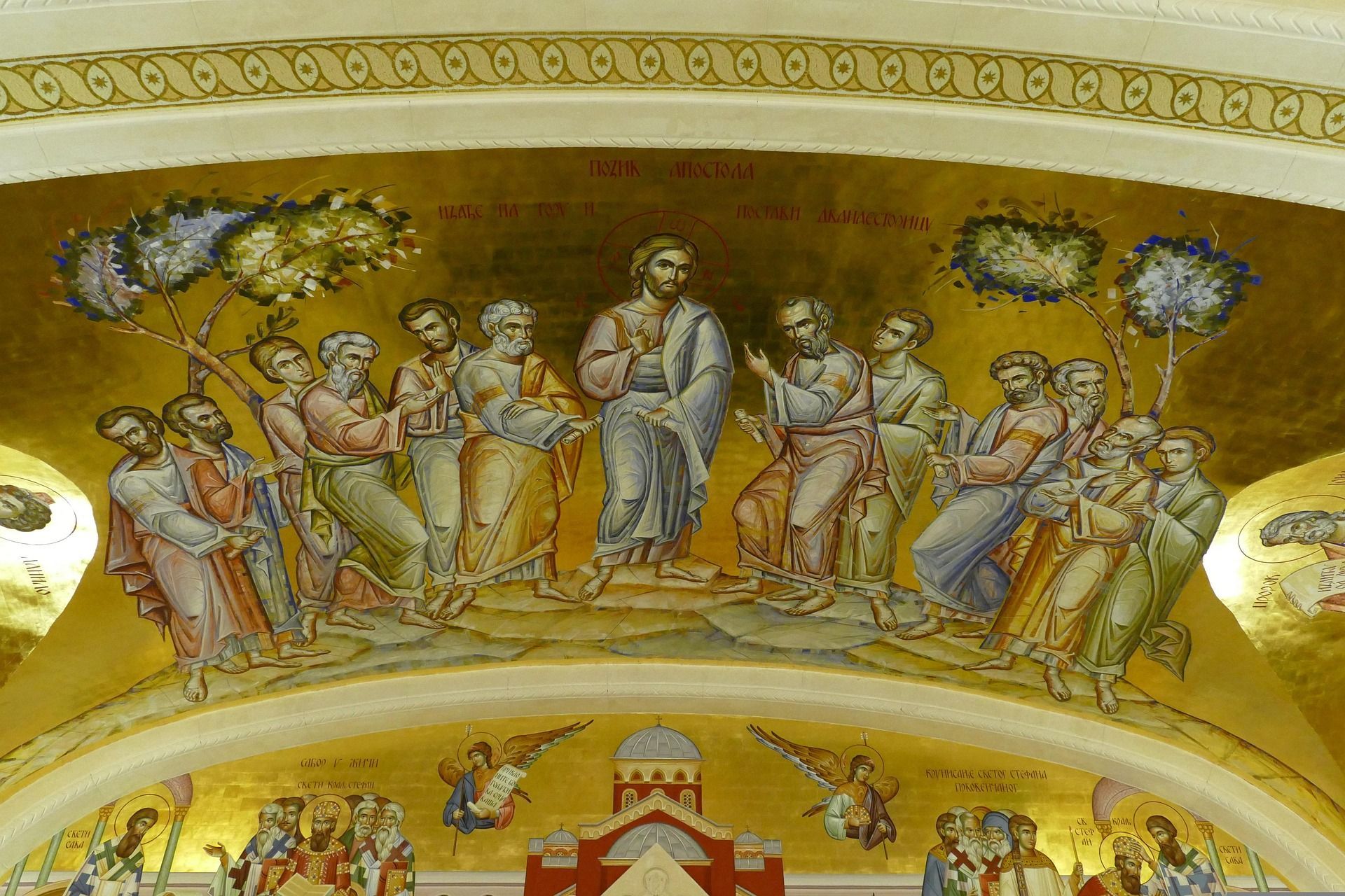 Un mural de estilo bizantino sobre un fondo dorado que representa a Jesucristo de pie y enseñando a sus doce apóstoles.