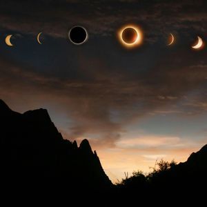 Die Phasen einer Sonnenfinsternis bilden einen Bogen am bewölkten Himmel über einer silhouettierten Bergkette in der Dämmerung.