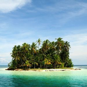 Una pequeña isla tropical cubierta de palmeras, rodeada de aguas turquesas y cristalinas bajo un cielo azul con nubes ligeras.