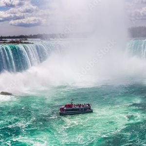 L'Empire State Building, con la sua cima illuminata da luci rosse, si erge maestoso in un denso skyline cittadino al tramonto.