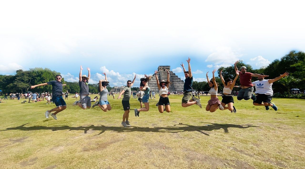 Group of people jumping in front of Chichen Itza in Mexico - WeRoad
