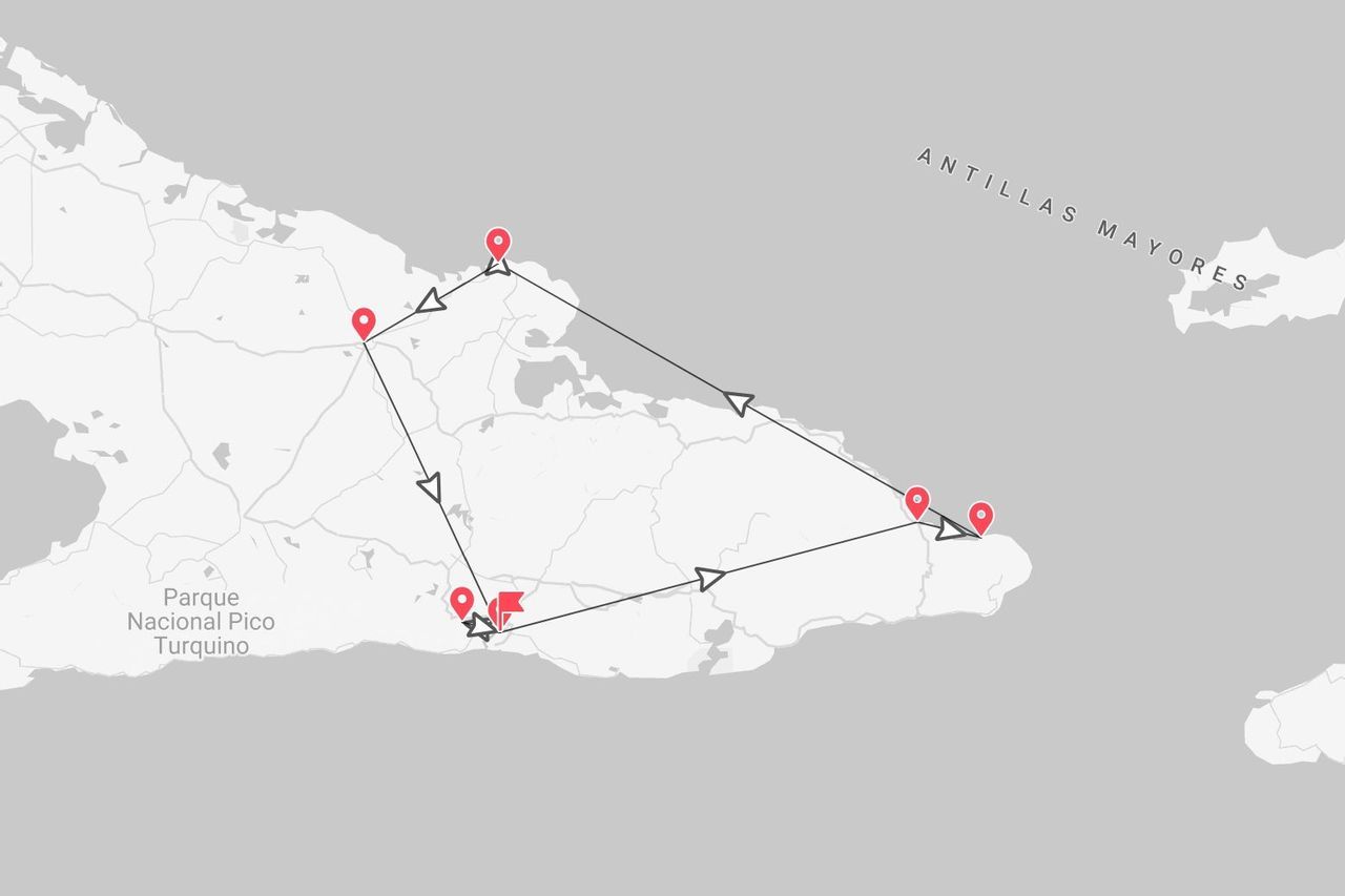 Un mapa que muestra una ruta de viaje en las Antillas Mayores, pasando cerca del Parque Nacional Pico Turquino, con puntos rojos indicando paradas.