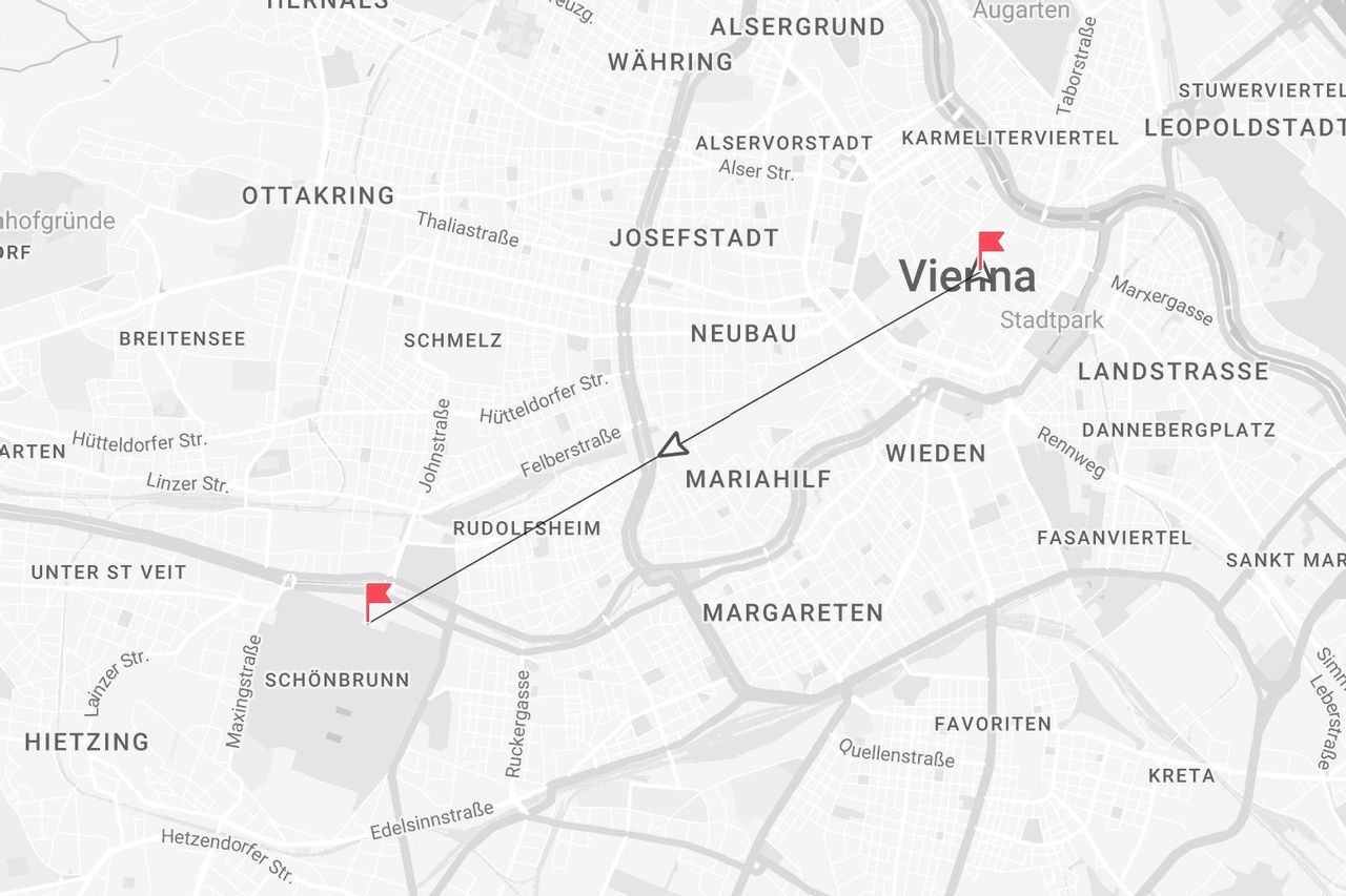 Una mappa in scala di grigi di Vienna, Austria, che mostra un percorso dal distretto di Schönbrunn al centro città segnato da una linea e bandiere rosse.