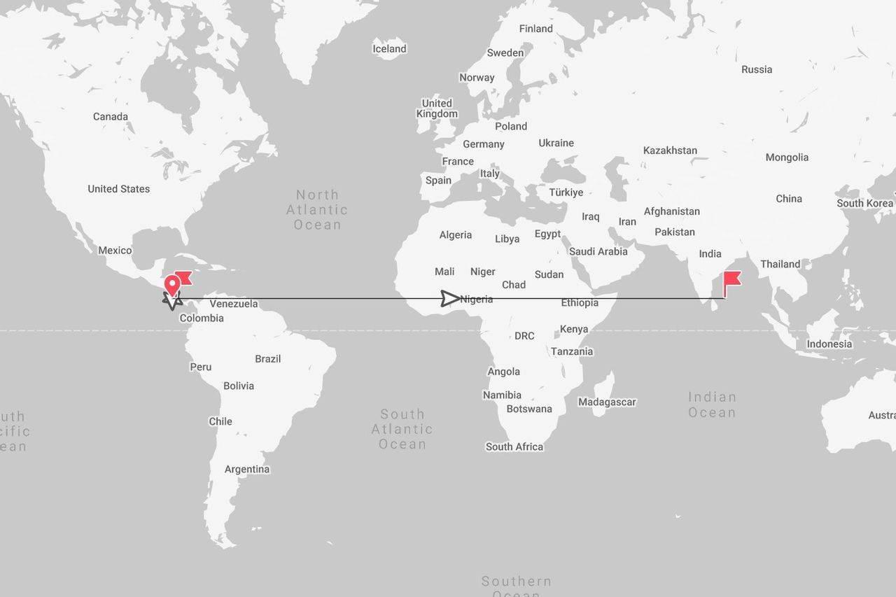 Una mappa del mondo in scala di grigi che mostra un itinerario di viaggio con una linea che collega la Colombia in Sud America alla Thailandia nel Sud-est asiatico.