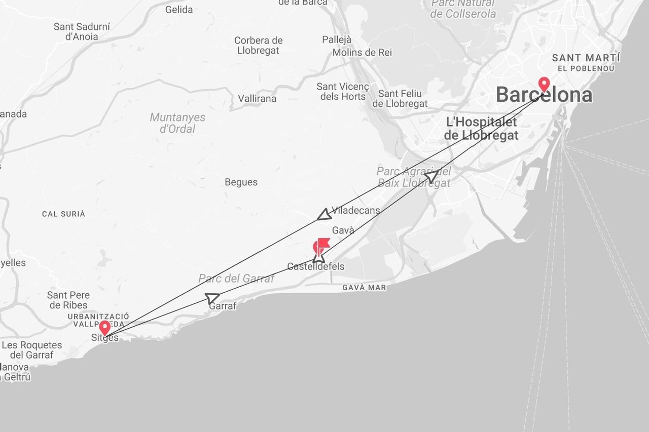 Una mappa in scala di grigi che mostra l'itinerario di viaggio da Barcellona a Sitges, Spagna, passando per città come Castelldefels e Garraf.