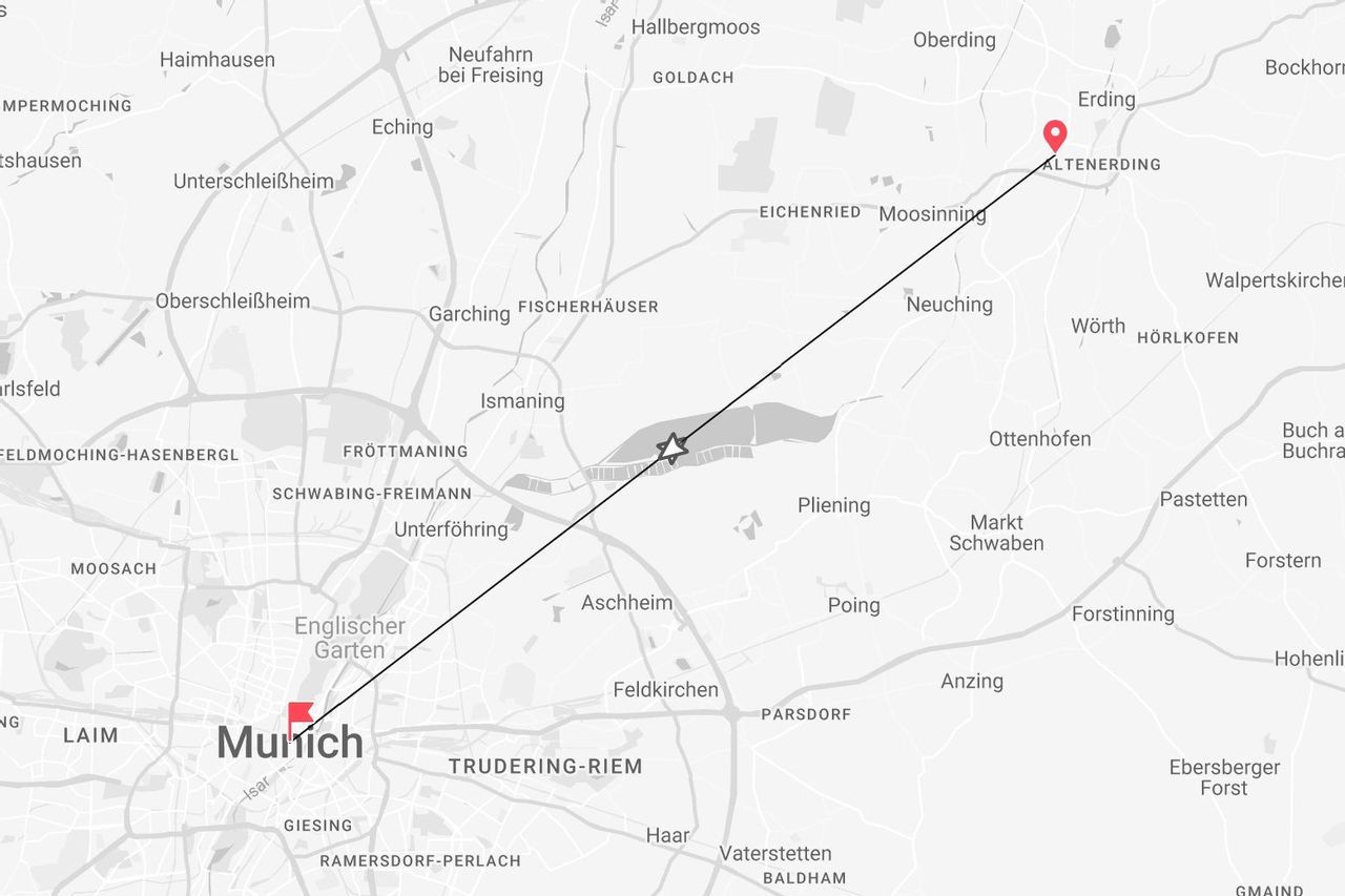 Una mappa in scala di grigi che mostra un percorso in linea retta che collega Monaco ed Erding, passando su varie città e strade.