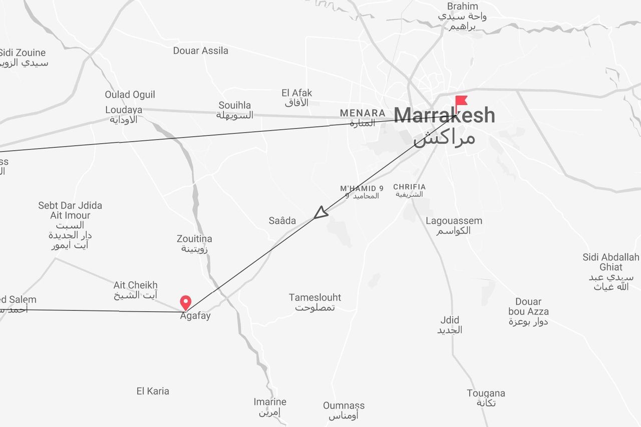 Un mapa en escala de grises mostrando la ruta de viaje de Marrakech a Agafay en Marruecos, con nombres de lugares en inglés y árabe.