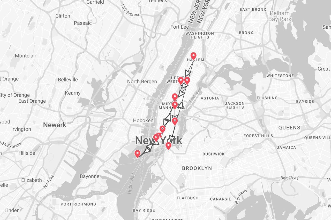 Une carte en niveaux de gris de New York montrant un itinéraire de voyage avec des épingles rouges marquant un parcours sur toute la longueur de Manhattan.