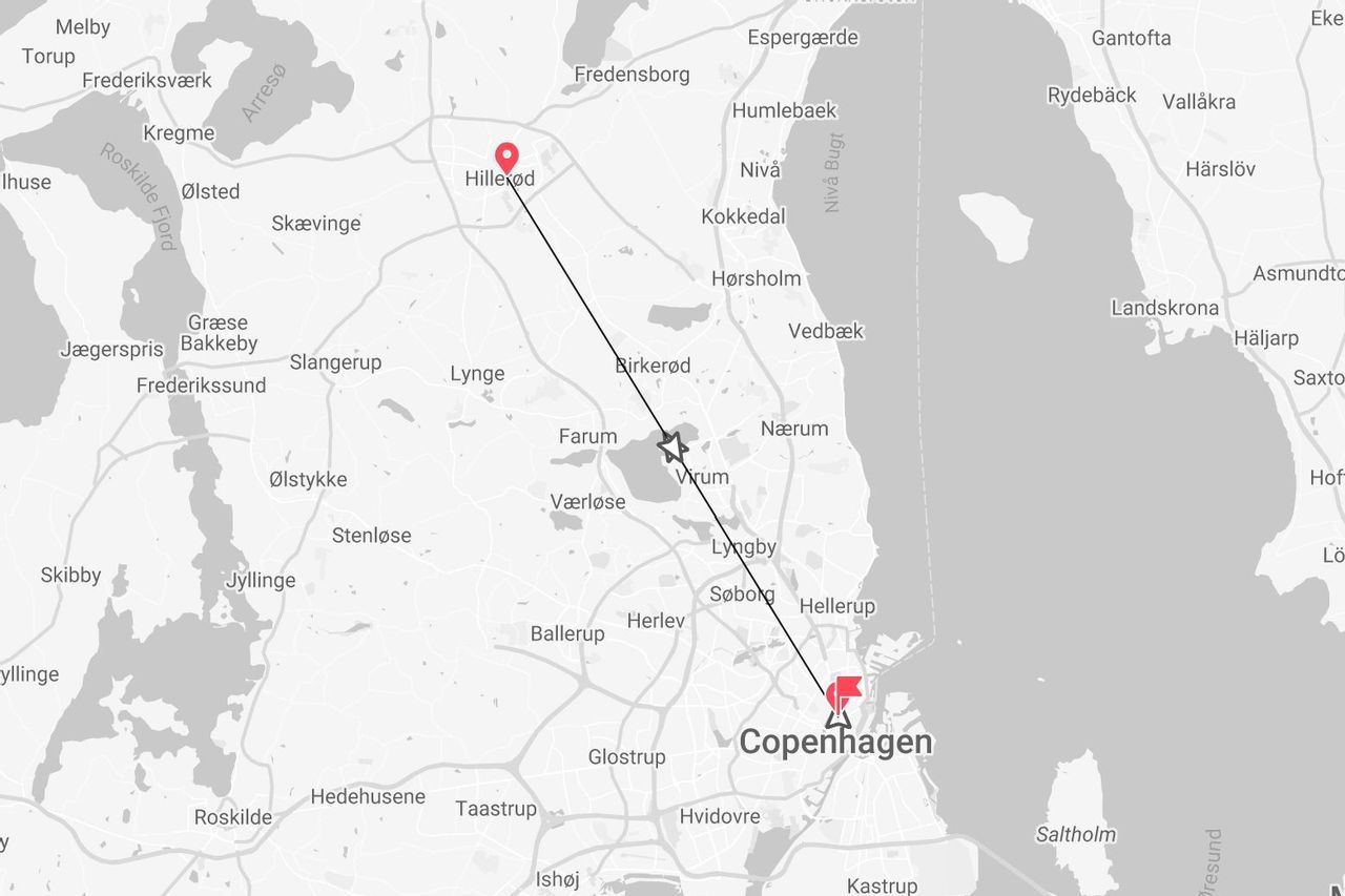 A grayscale map showing a direct route between the city of Hillerød and Copenhagen in Denmark.