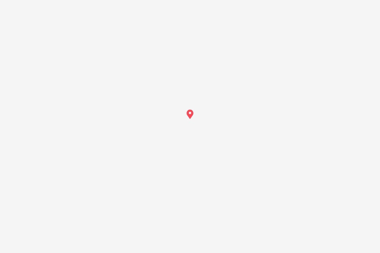 Un pin de mapa rojo centrado sobre un fondo gris claro.