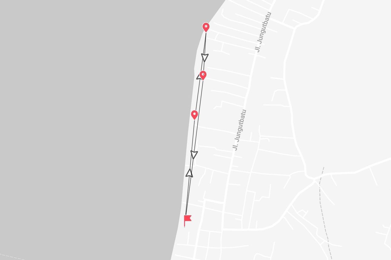 Una mappa stilizzata che mostra un itinerario di viaggio lungo una costa, con punti di interesse segnati vicino a una strada chiamata Jl. Jungutbatu.