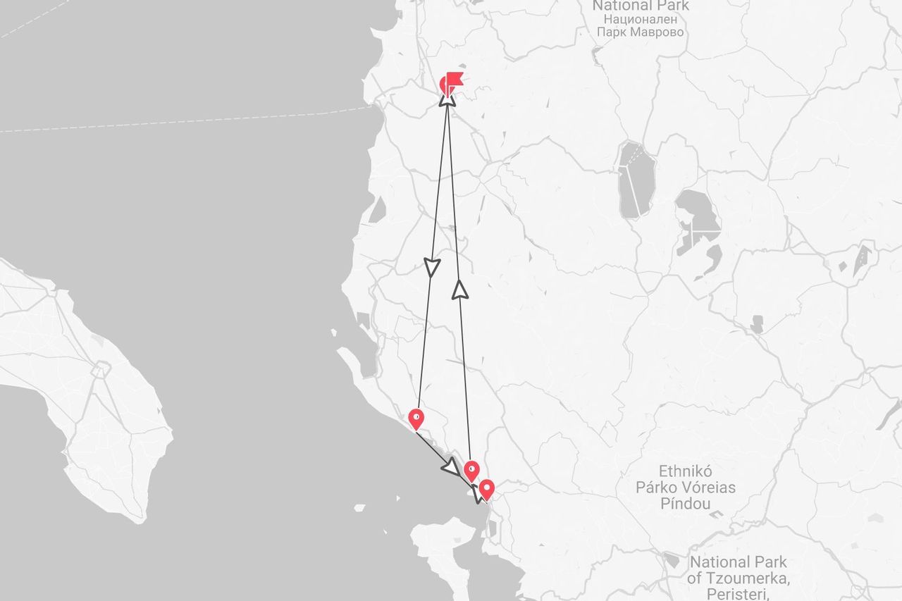 Una mappa in scala di grigi che illustra un itinerario di viaggio con puntine rosse e frecce attraverso il Parco Nazionale di Mavrovo e il Parco Nazionale del Pindo Settentrionale.