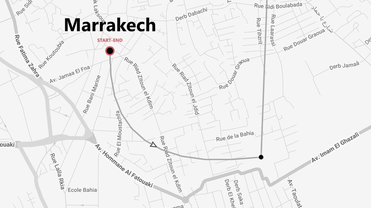 Une carte en niveaux de gris de Marrakech montrant un itinéraire balisé avec un point de départ et d'arrivée à travers les rues de la ville.