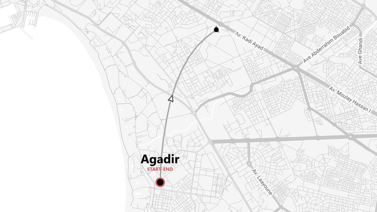 Une carte en niveaux de gris illustrant un itinéraire de voyage à travers la ville d'Agadir, avec les points de départ et d'arrivée clairement indiqués.