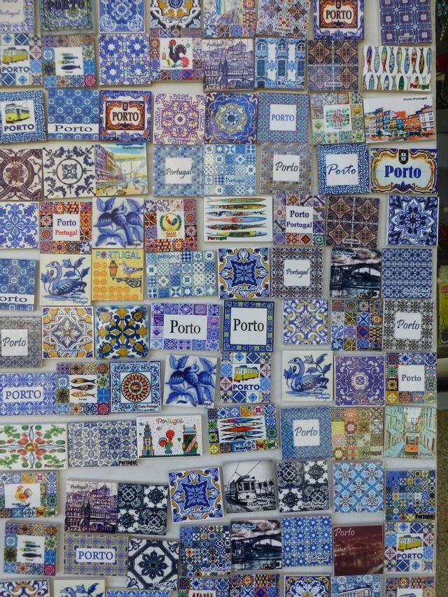 Portugiesische Souvenirmagnete mit blau-weißen Azulejo-Kachelmotiven, Hähnen und dem Schriftzug 'Porto'.