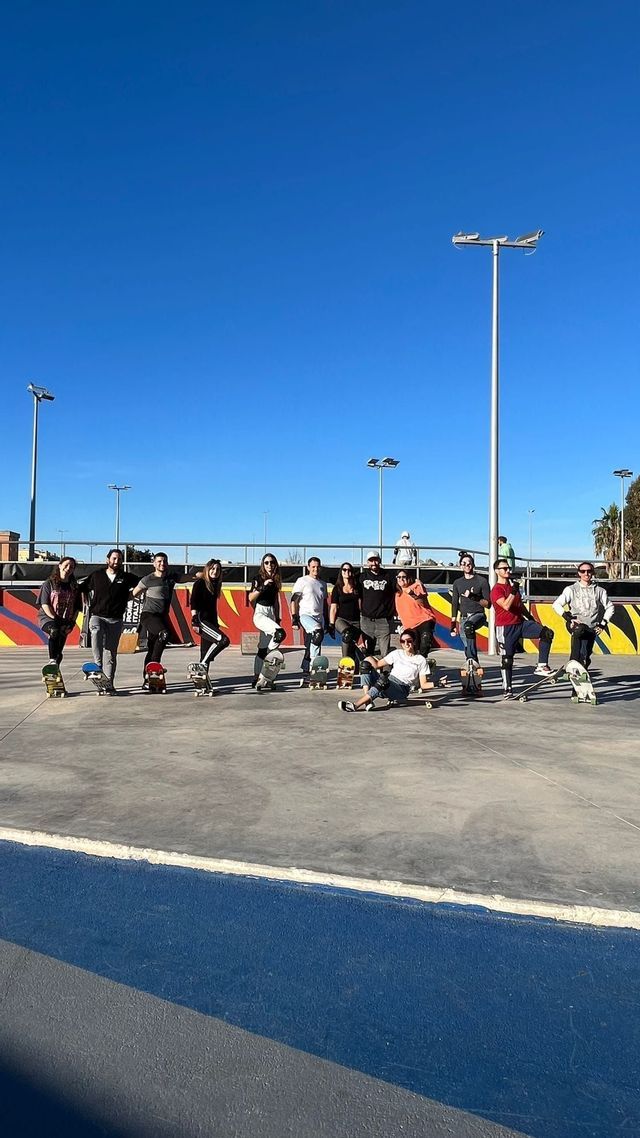 Un gruppo WeRoad in posa con i loro skateboard in uno skatepark all'aperto sotto un cielo azzurro.