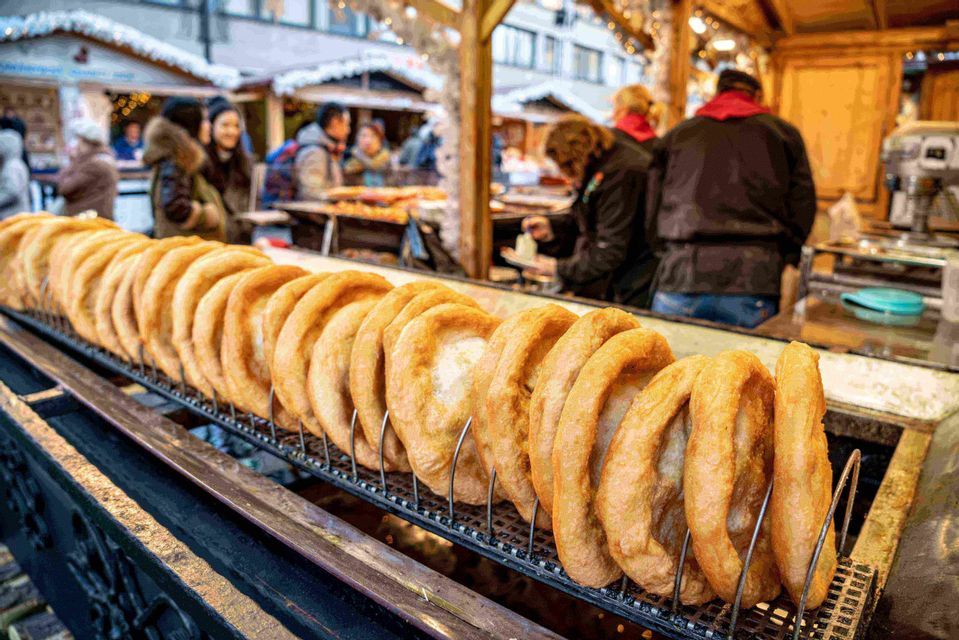 Chimney cakes turning on a grill at a street food stall in Budapest.