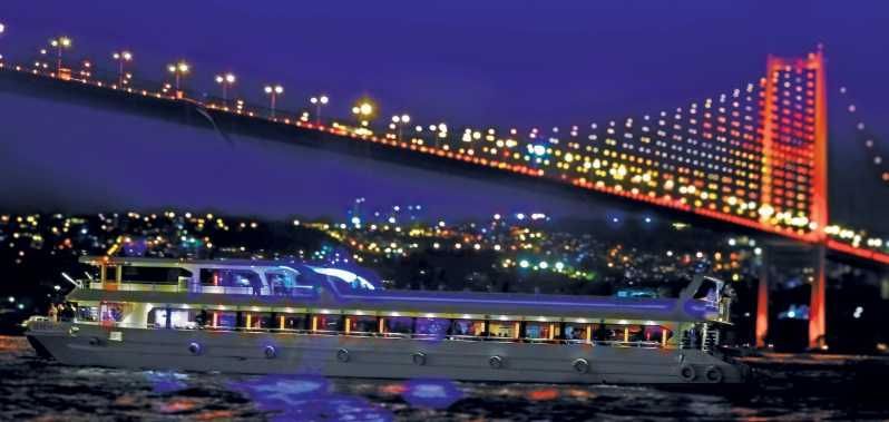 Un viaje en grupo de WeRoad en un barco iluminado navega de noche con un gran puente iluminado y el horizonte de la ciudad de fondo.