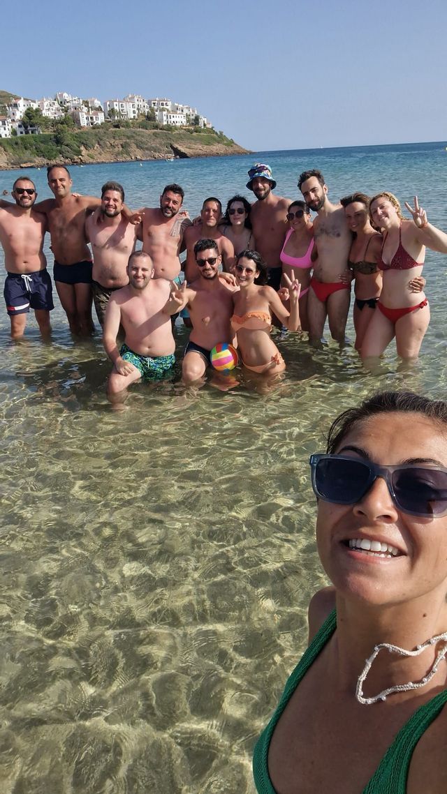 Un gruppo WeRoad posa per un selfie stando nell'acqua limpida e bassa del mare in una giornata di sole.