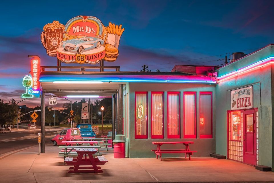 L'extérieur de Mr. D'z, un diner rétro de la Route 66, s'illumine de néons colorés au crépuscule.
