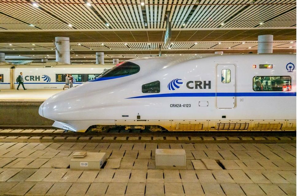 Frente de un tren CRH de alta velocidad blanco estacionado en un andén dentro de una estación moderna y bien iluminada.