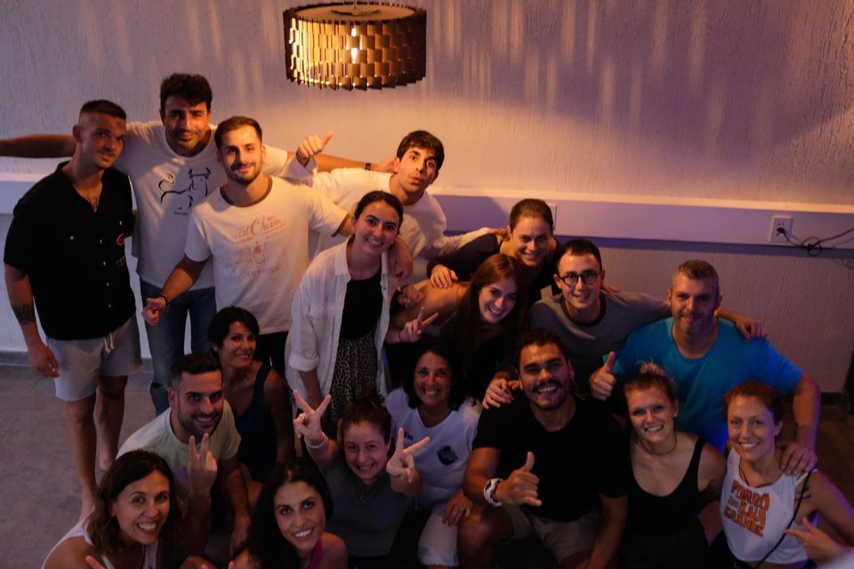WeRoad Gruppenreise: Lächelnde Menschen posieren gemeinsam für ein Foto unter einer modernen Leuchte im Innenbereich.