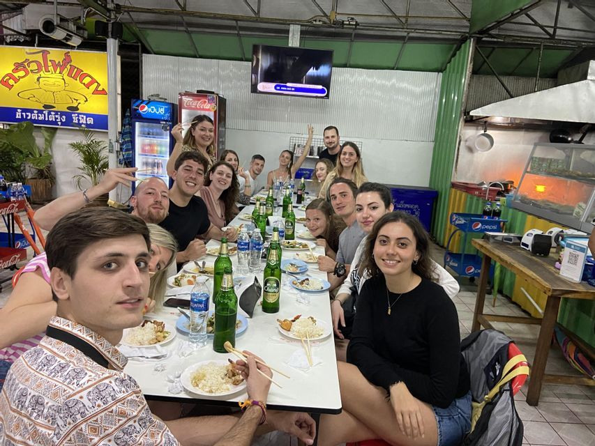 Un gruppo WeRoad a cena in un ristorante locale, seduto a un lungo tavolo e sorridendo alla macchina fotografica.