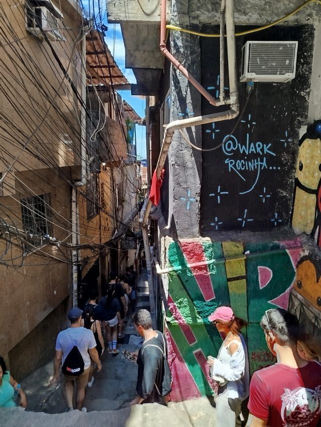 Un viaje en grupo de WeRoad baja escaleras en un estrecho callejón urbano con paredes cubiertas de grafitis y cables eléctricos enredados.