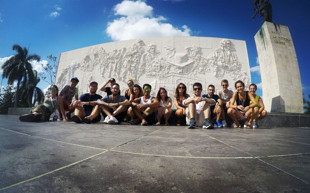 Eine WeRoad-Gruppe posiert für ein Foto vor einem großen, weißen Denkmal unter blauem Himmel.