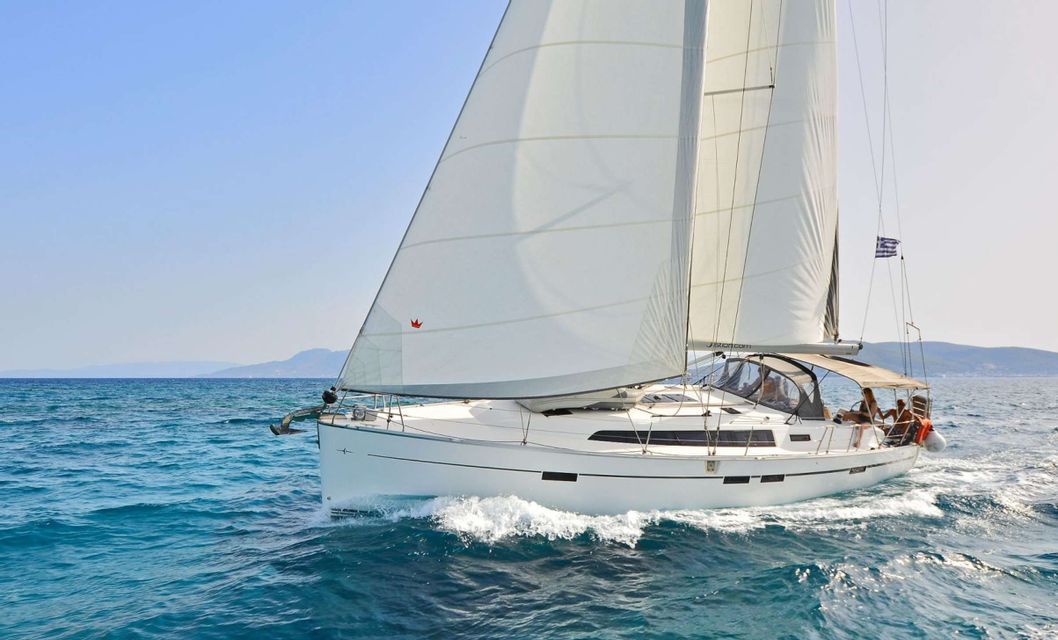 A WeRoad group trip on a sailboat cruising through blue waters with its white sails full under a clear sky.