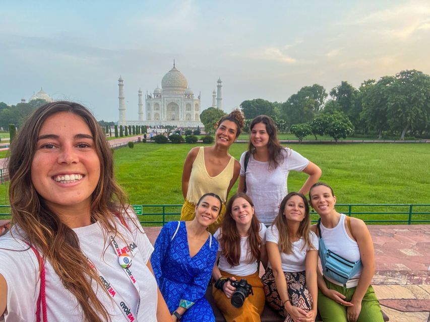 Eine WeRoad Gruppenreise lächelnder Frauen macht ein gemeinsames Selfie vor dem Taj Mahal.