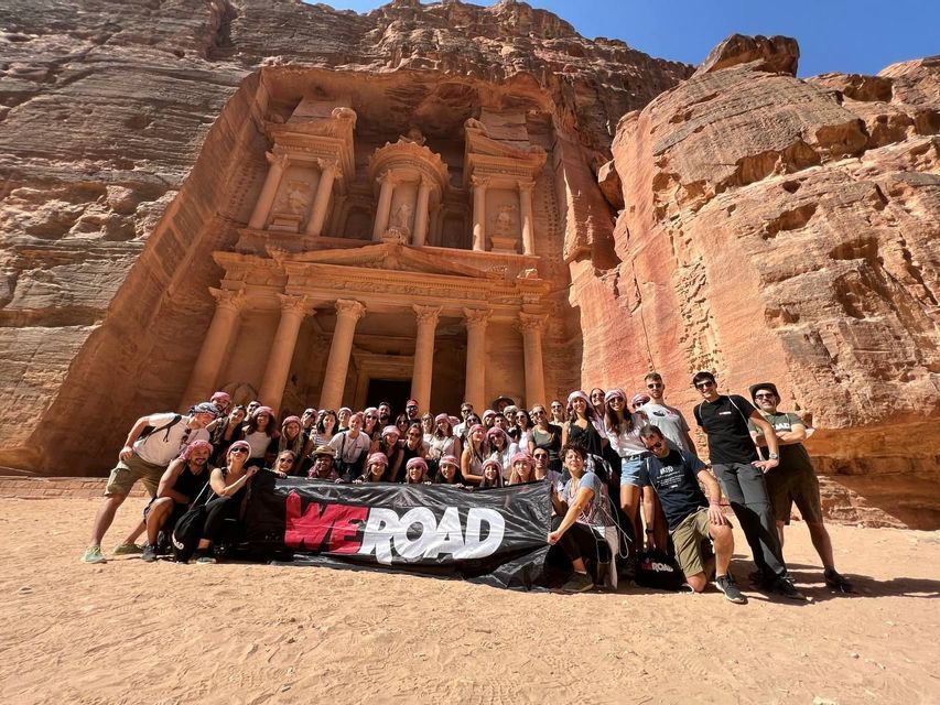 Foto di gruppo del WeRoad Team di fronte al Tesoro di Petra in Giordania