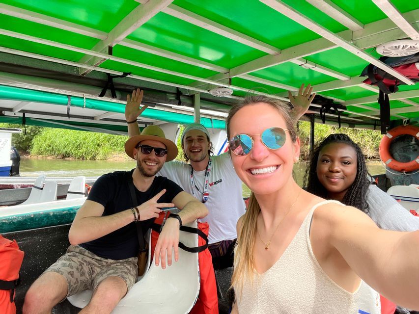Un viaggio di gruppo WeRoad di quattro persone che sorridono per un selfie su una barca coperta durante un'escursione fluviale.