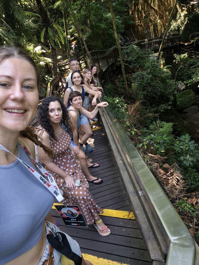 Un grupo de WeRoad se hace un selfie en una pasarela de madera en una selva exuberante y verde.