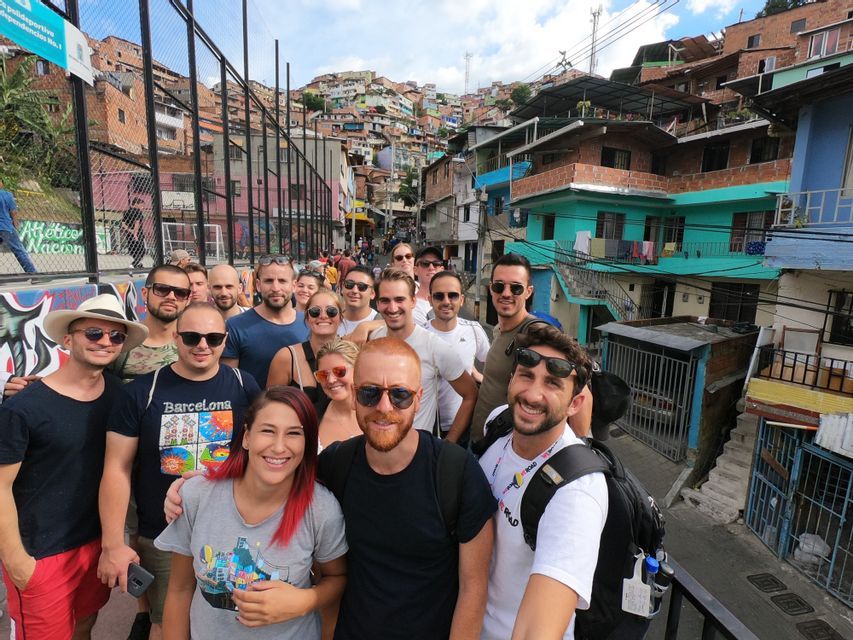 Un gruppo WeRoad si scatta un selfie su una strada con case colorate costruite su una ripida collina sullo sfondo.