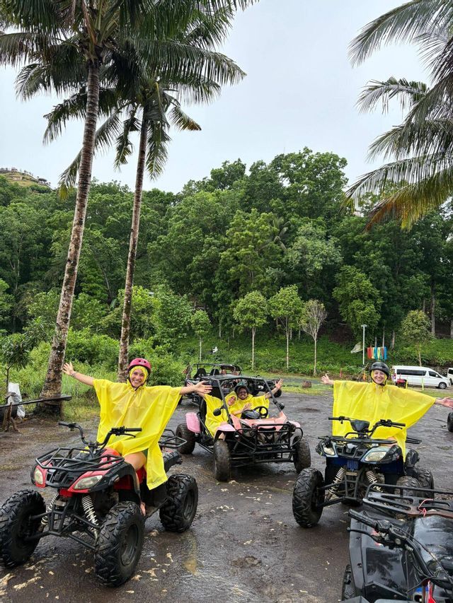 Un gruppo WeRoad in viaggio con poncho antipioggia gialli, in posa su quad e un buggy nella giungla tra le palme.