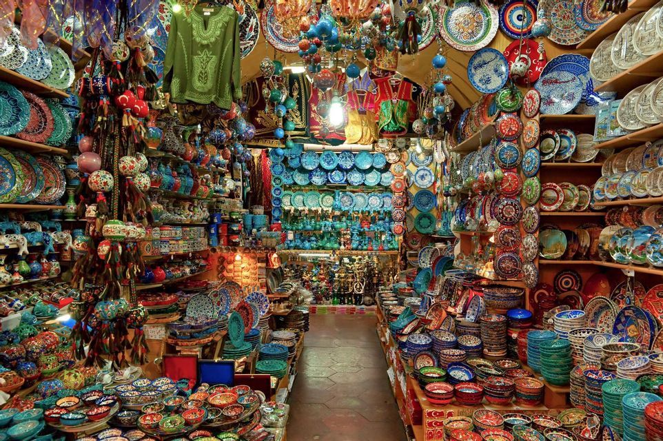 El interior de una tienda de recuerdos repleta de estantes con coloridos platos de cerámica pintados a mano, cuencos y artesanías turcas tradicionales.