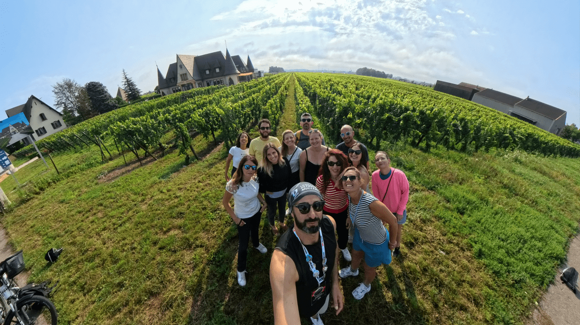 Un uomo si scatta un selfie del suo viaggio di gruppo WeRoad, posando insieme in un sentiero tra filari di viti in un vigneto.