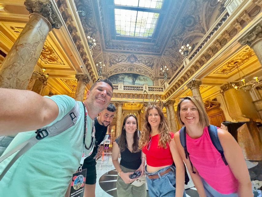 Un grupo de WeRoad en un viaje haciéndose un selfi dentro de un edificio ornamentado con columnas de mármol y un techo decorado.