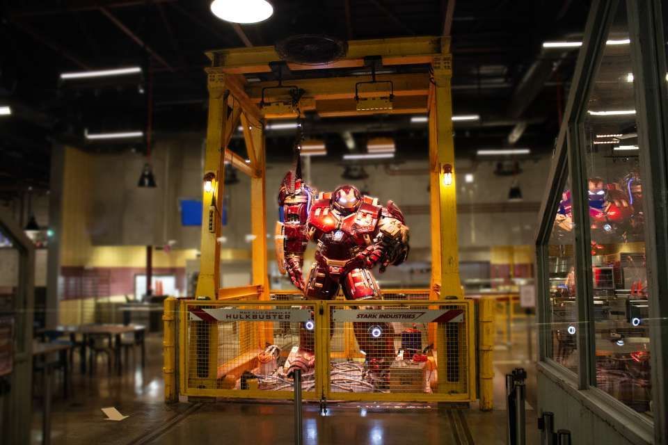 Un modello a grandezza naturale dell'armatura Hulkbuster di Iron Man si trova all'interno di un portale industriale giallo etichettato 'Stark Industries'.