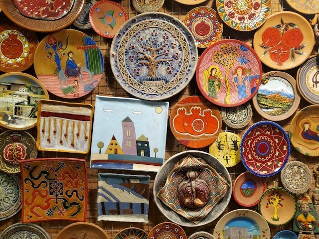 A collection of colorful, hand-painted ceramic plates and tiles with intricate designs covering a wall.
