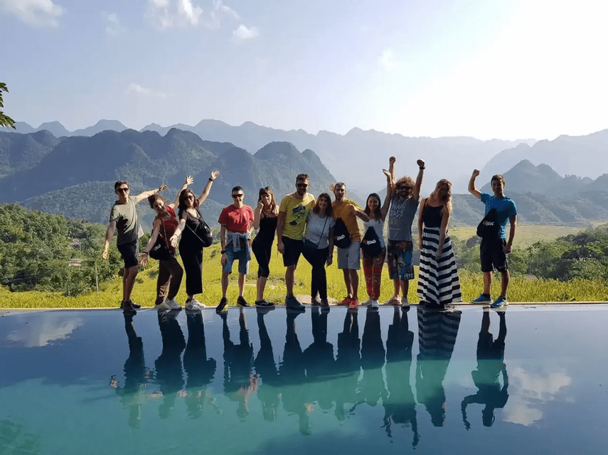 Un viaggio di gruppo WeRoad si fa immortalare sul bordo di una piscina a sfioro, con i riflessi nell'acqua e un paesaggio montuoso sullo sfondo.