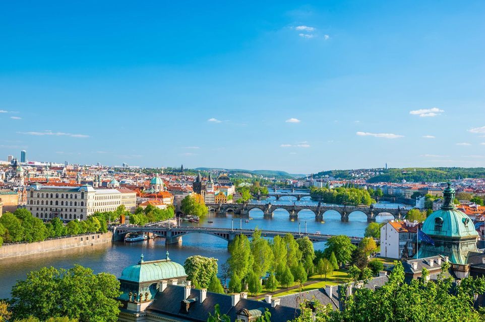 Aerial view of the Vltava river and its bridges crossing Prague on a clear day.
