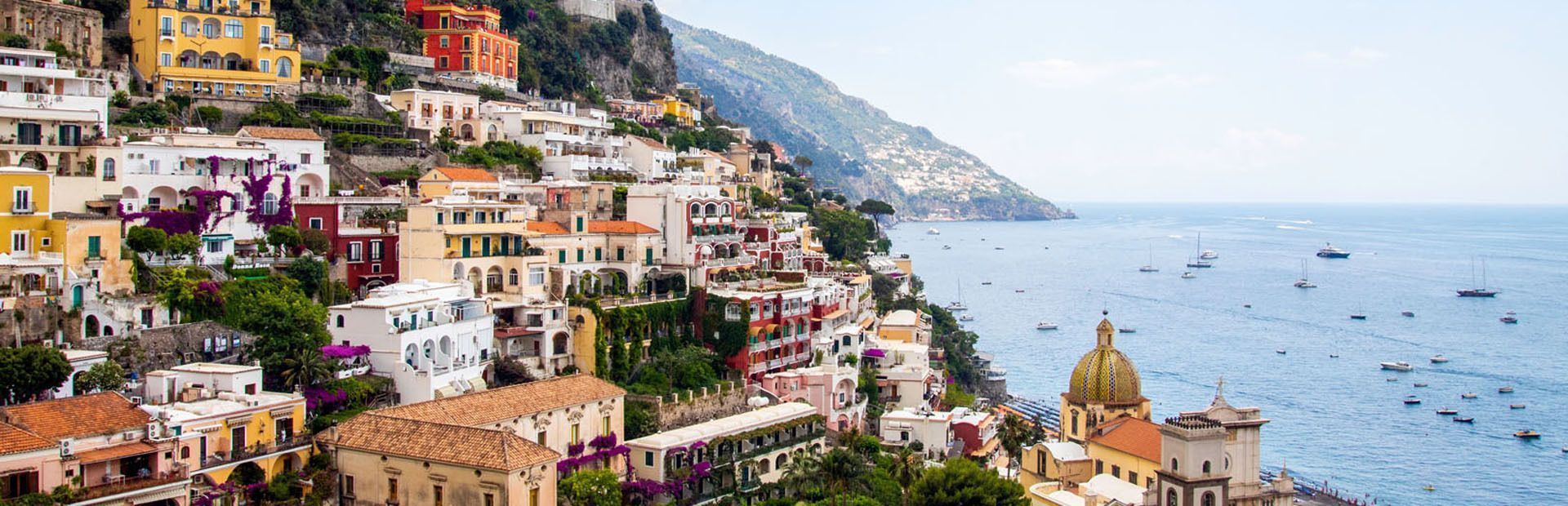 Viaja en grupo con gente de tu edad con WeRoad y descubre Nápoles y la Costa Amalfitana en un viaje express Casas típicas de la Costa Amalfitana sobre un acantilado en Positano